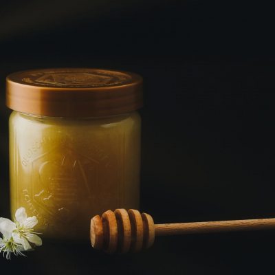 Jar of honey with a honey dipper.